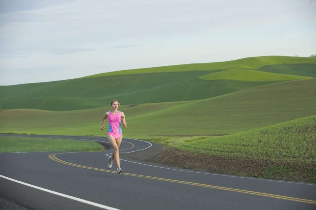 Runner on rural road in farm land