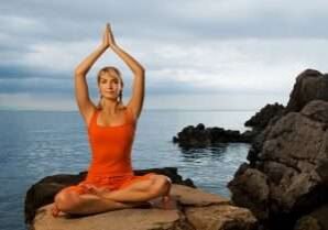 Beautiful young woman doing yoga exercise outdoors